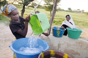 Mädchen schöpfen Brunnenwasssr